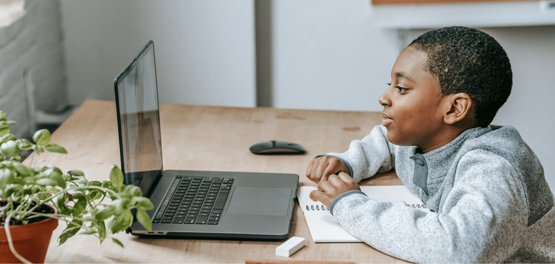 A young student focused on an online lesson at his desk